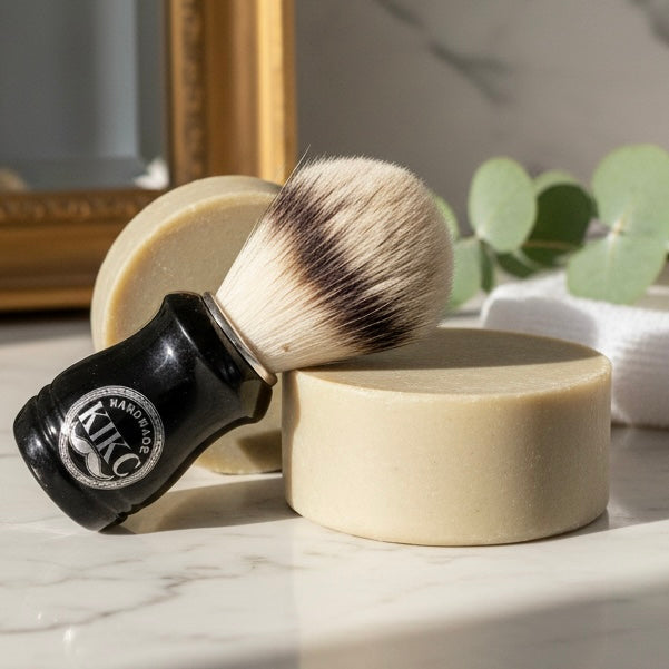 Shaving brush and soap on a marble surface with a decorative background